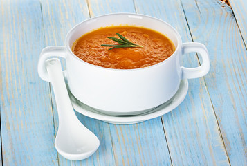 Pumpkin soup in a bowl on a wooden background
