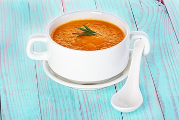 Pumpkin soup in a bowl on a wooden background