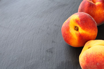 Fresh peaches on slate background
