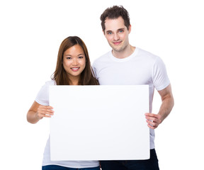 Couple holding white poster together