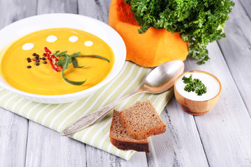 Pumpkin soup in white plate and pumpkin slice