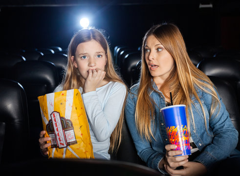 Woman Looking At Scared Daughter Watching Movie