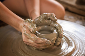 "Potter hands making in clay on pottery wheel