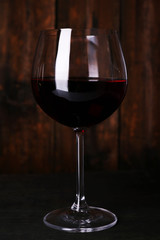 Red wine glass of wine on wooden background