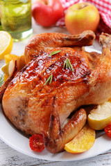 Delicious baked chicken on plate on table close-up