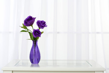 Beautiful bouquet of flowers in vase on window background