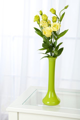Beautiful bouquet of flowers in vase on window background