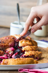Yeast blueberry pie cut into pieces, hands