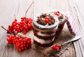 Delicious dessert in jars on table close-up