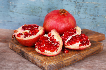Juicy ripe pomegranates on old wooden table