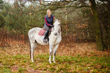 Fototapeta premium Young woman riding a horse