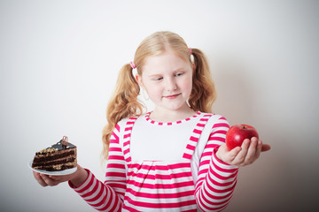 Girl choose from sweet cake and red apple