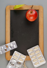 Tafel mit Medizin und Apfel