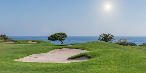 Poster Panorama van een golfbaan op de achtergrond van een zee. voor toeristen. © sergojpg
