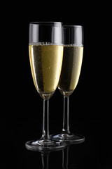 Two champagne flutes on black