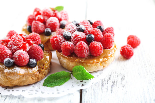 Sweet cakes with berries on table close-up