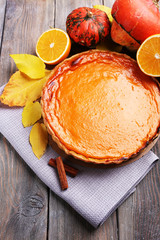 Homemade pumpkin pie on napkin, on wooden background