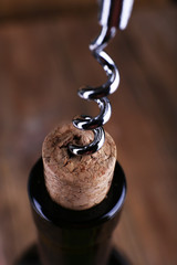 Bottle opener close-up, on wooden background