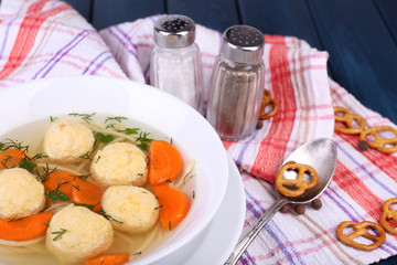 Soup with meatballs and noodles in bowl on wooden background
