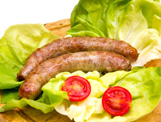 Sausage on wooden cutting board with salad