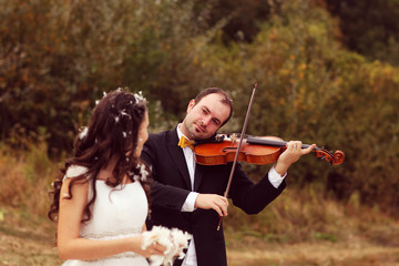groom playing violin and bride dancing