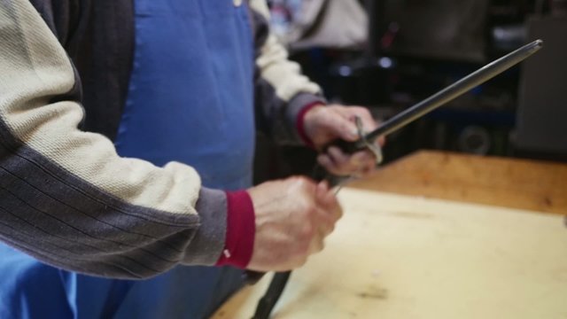 Old butcher sharpening his knife in slow motion