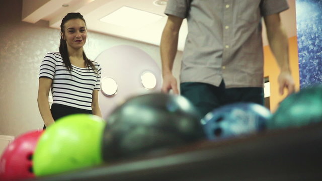 Man and woman kissing in a bowling alley