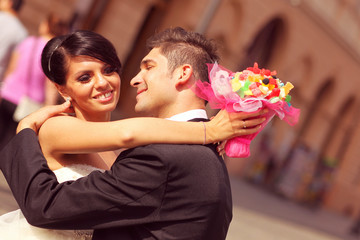 Bride and groom kissing and embracing in the city