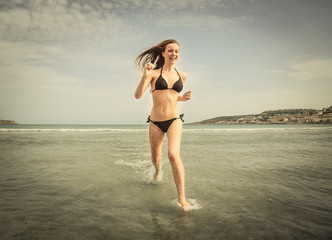 Fototapeta na wymiar Girl running in the water