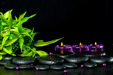 spa concept of zen basalt stones with drops, lilac candles, bead