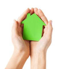 hands holding green paper house