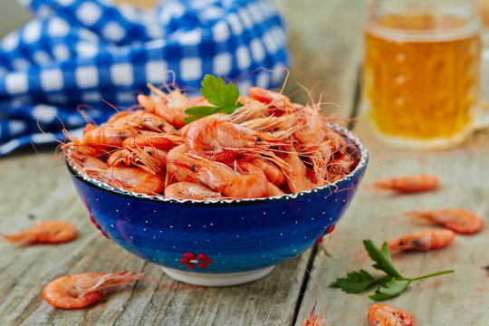 Prepared shrimp on blue plate on wooden background