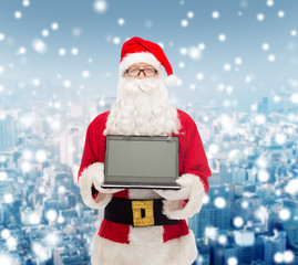 man in costume of santa claus with laptop
