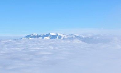 Top of high mountains, covered by snow and fog