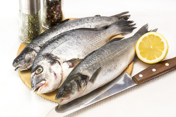 raw fish on a cutting board and knife