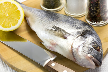 raw fish on a cutting board and knife
