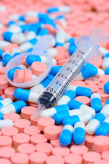 syringe with  spoon on many  pills and capsules