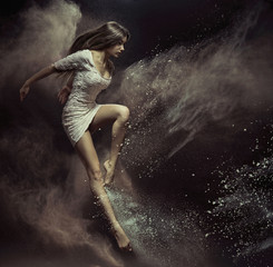 Jumping girl in full of dust place
