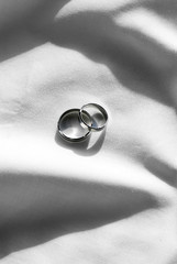 Two wedding ring on white fabric