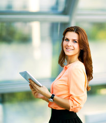 Fototapeta na wymiar Young smiling business woman holding digital tablet
