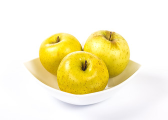 three yellow apples in a white bowl