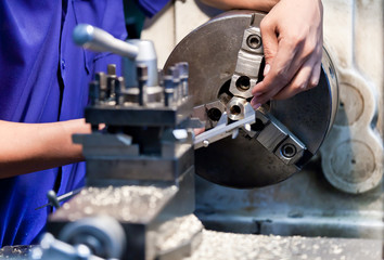 Milling machine operator working in factory workshop