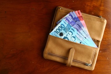 Cash money in a leather wallet