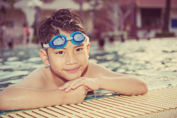 Portrait of happy little boy playing in the pool