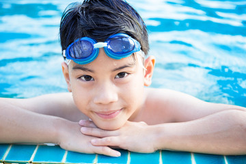 Portrait of happy little boy playing in the pool