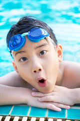 Portrait of happy little boy playing in the pool