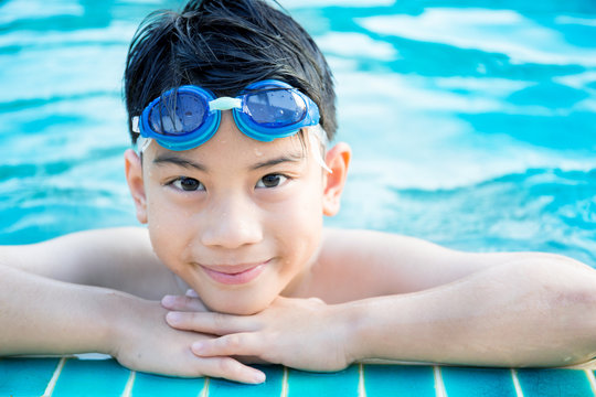 Portrait of happy little boy playing in the pool