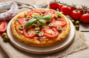 Italian cuisine: pizza with ham and tomatoes