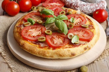 Italian cuisine: pizza with ham and tomatoes