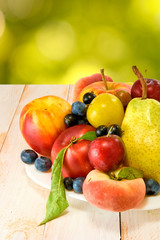 different fruits on a plate on a green background